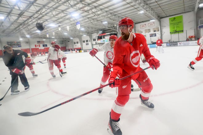 Defenseman Filip Hronek, right, tries to stop a flying puck during the Red Wings’ training camp at Centre Ice Arena.