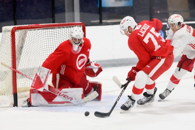 Center Cedric Lacroix tries to get the puck past goaltender Sebastian Cossa during the Red Wings’ training camp at Centre Ice Arena.