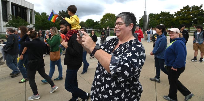 Co-organizer Mary Kay Kubicek, of Dearborn, takes pictures at the end of the rally, Sunday afternoon, September 25, 2022.
