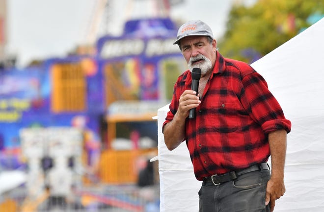 Dan McDonough of Jack Pine Lumberjack Shows, emcee and also 9-time lumberjack world champion, keeps the jokes coming during the show at the Fire & Flannel Festival in Wyandotte, Mich. on Sept. 25, 2022.