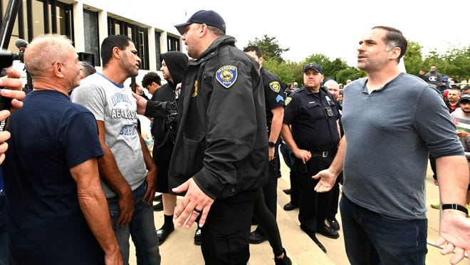 Dearborn police officers separate Rally To Protect Our Children attendees from counter protester Nathan Gabrish, right, of Dearborn, near the end of the rally, Sunday afternoon, September 25, 2022.