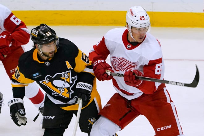 Penguins' Kris Letang (58) and Red Wings' Elmer Soderblom (85) vie for position during the first period.