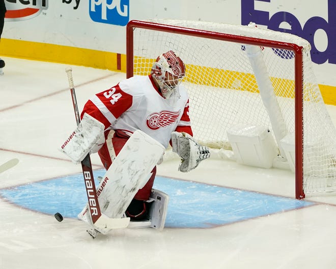 The puck bounces out of the net past Red Wings goalie Victor Brattstrom after Penguins' Brock McGinn scored during the first period.