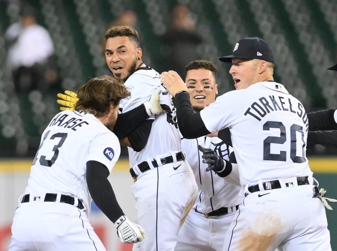 Tigers' Eric Haase (13), Spencer Torkelson (20) and Javier Báez swarm Harold Castro, second from left, after he hits a walk-off single in the 10th inning.