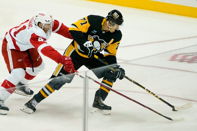 Penguins' Evgeni Malkin (71) brings the puck up ice as Red Wings Jared McIsaac pursues during the first period.