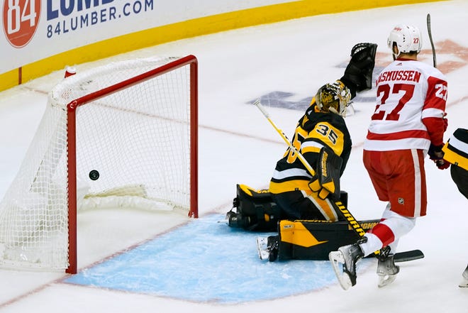 The puck bounces in the net as Red Wings' Michael Rasmussen (27) watches it get by Penguins goaltender Tristan Jarry (35) on a shot by Dominik Kubalik during the first period.