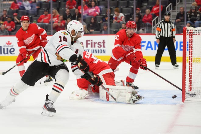 Chicago left wing Jujhar Khaira slips the puck past Detroit goaltender Jussi Olkinuora and defenseman Albert Johansson for a goal during the second period.