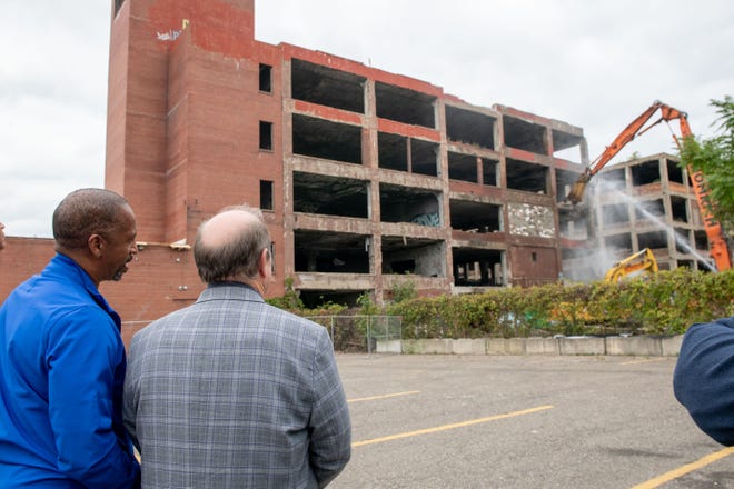 Detroit council member Scott Benson, left, and Detroit Mayor Mike Duggan watch as demolition equipment begins work on tearing down one building of the former Packard plant, in Detroit, September 29, 2022.