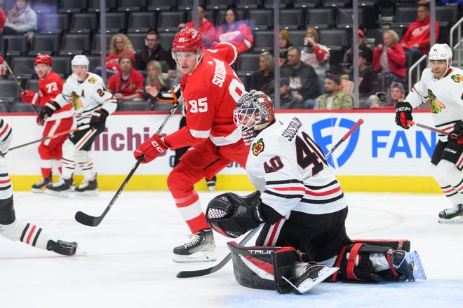 Detroit left wing Elmer Soderblom tries to get the puck past his older brother Chicago goaltender Arvid Soderblom during the first period of a preseason game between the Detroit Red Wings and the Chicago Blackhawks at Little Caesars Arena, in Detroit, September 28, 2022.