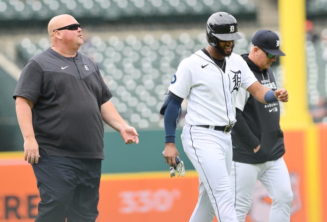 Tigers' Willi Castro exits the game after he doubles in the fourth inning with head athletic trainer Doug Teter, left, and manager AJ Hinch.