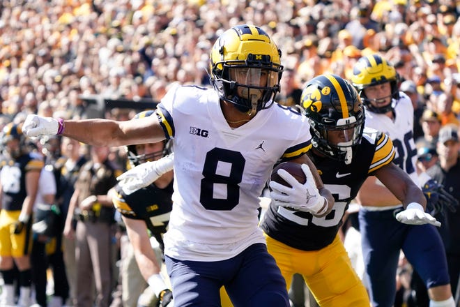 Michigan wide receiver Ronnie Bell (8) runs from Iowa defensive back Kaevon Merriweather (26) during a 16-yard touchdown run in the first half.