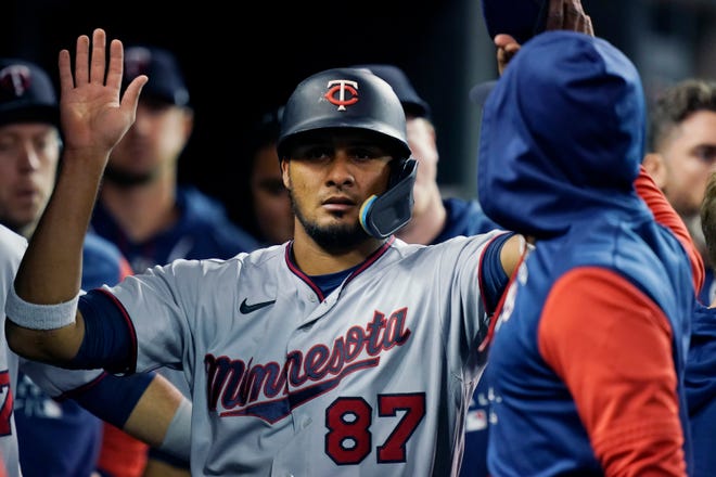 Minnesota Twins' Jermaine Palacios is greeted in the dugout after scoring on a double by Mark Contreras during the third inning.