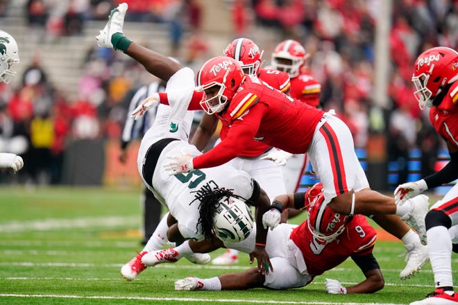 Michigan State tight end Maliq Carr, left, is upended by Maryland defensive lineman Mosiah Nasili-Kite, top, and linebacker Fa'Najae Gotay (9) while running with the ball during the first half.