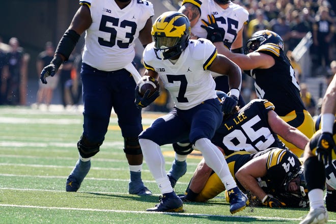 Michigan running back Donovan Edwards (7) carries the ball upfield during the first half.