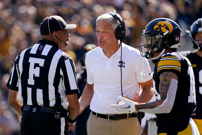 Iowa head coach Kirk Ferentz, center, and wide receiver Arland Bruce IV, right, question a penalty during the second half.