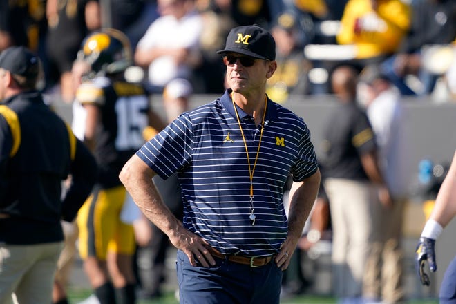 Michigan head coach Jim Harbaugh watches his team warm up before the game.