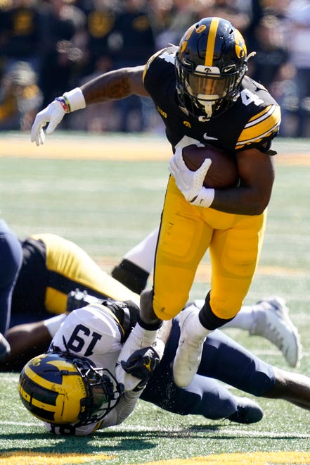 Iowa running back Leshon Williams (4) runs from Michigan defensive back Rod Moore (19) during the second half.