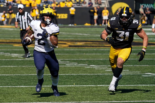Michigan running back Blake Corum (2) runs from Iowa linebacker Jack Campbell (31) during a 20-yard touchdown run in the second half.