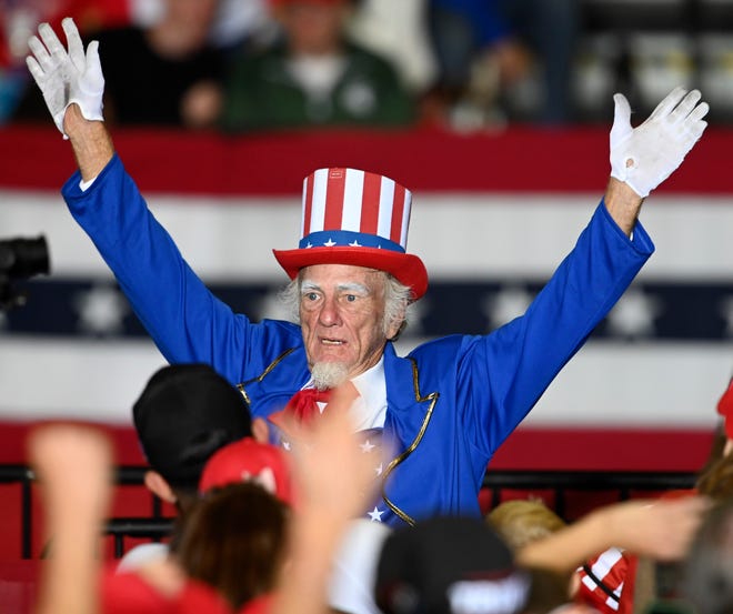 A man dressed up as Uncle Sam puts up his arms as the crowd chants, Ôlock her up, lock her up,Õ referring to MI Gov. Gretchen Whitmer, at a Donald Trump rally at the Macomb Community College Sports & Expo Center in Warren, Saturday, October 1, 2022.