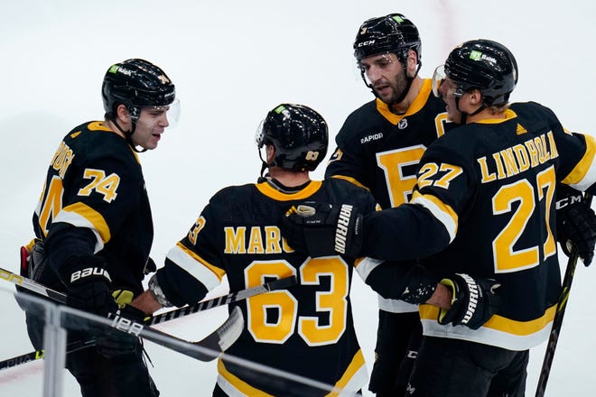 Boston Bruins left wing Brad Marchand (63) is congratulated after his goal during the second period of an NHL hockey game against the Detroit Red Wings, Thursday, Oct. 27, 2022, in Boston. Marchand, who underwent offseason double-hip surgery that was supposed to keep him out until the end of November, started the game.
