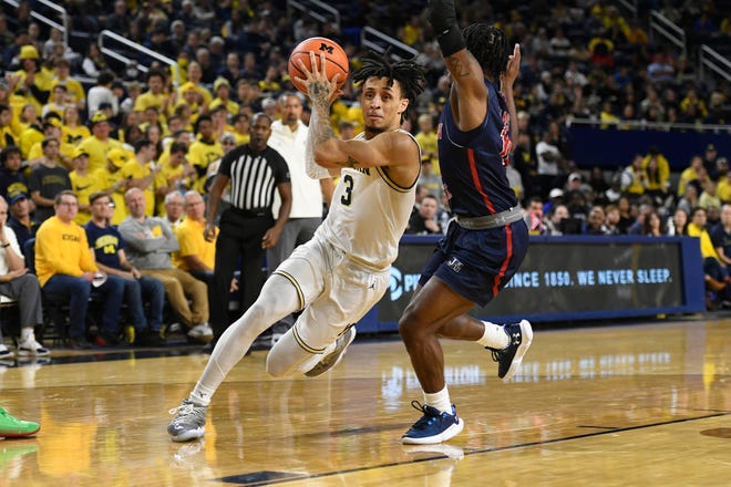 Michigan guard Jaelin Llewellyn, left, drives to the basket as he is guarded by Jackson State guard Chase Adams in the second half of an NCAA college basketball game, Wednesday, Nov. 23, 2022, in Ann Arbor, Mich. (AP Photo/Jose Juarez)