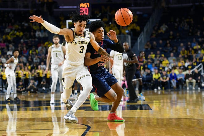 Going for the loose ball are Michigan guard Jaelin Llewellyn, left, and Jackson State guard Gabe Watson in the first half of an NCAA college basketball game, Wednesday, Nov. 23, 2022, in Ann Arbor, Mich. (AP Photo/Jose Juarez)