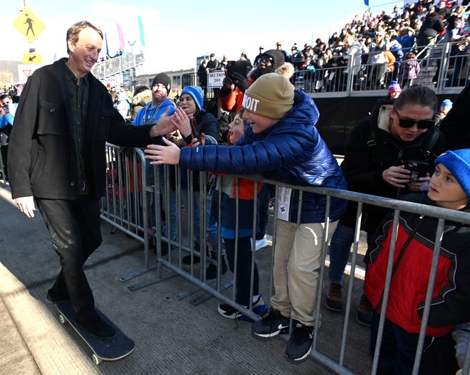 Skateboarding great Tony Hawk gives high fives to fans during the parade.