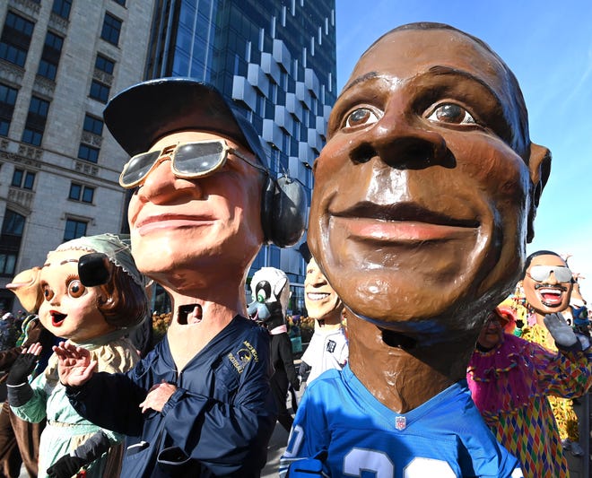 Bo Schembechler, center, and Barry Sanders are members of the Big Head Corps during the parade.