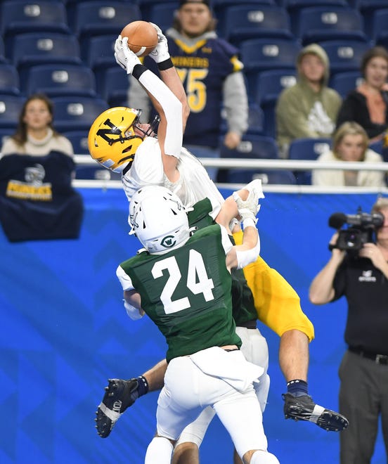Negaunee's Phil Nelson pulls down a touchdown reception over West Catholic's Danny Groskiewica and Joe Debski in the first half.
