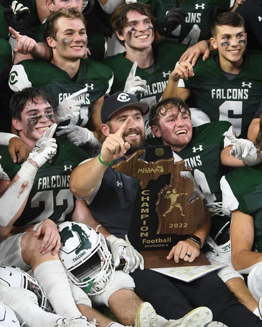 Grand Rapids West Catholic coach Landon Groove and the players pose for pictures after winning the Division 6 state championship.