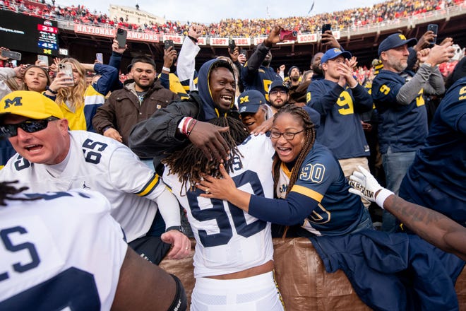 Michigan linebacker Mike Morris is hugged by the fans after the 45-23 win over Ohio State.