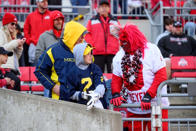 Tim Visser, of Grand Rapids, and his 13-year-old grandson Tryson Smallegan hang out with an Ohio State fan before the game.