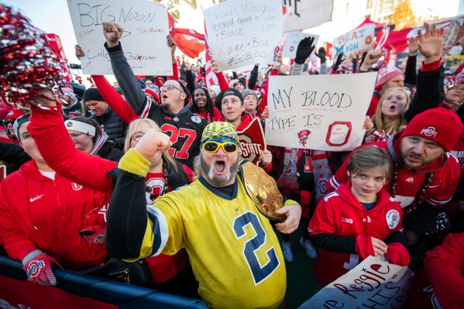 Michigan fan Hank Hogan, of Angola, Indiana, is outnumbered by Ohio State fans while watching the Fox Big Noon Kickoff before the game.