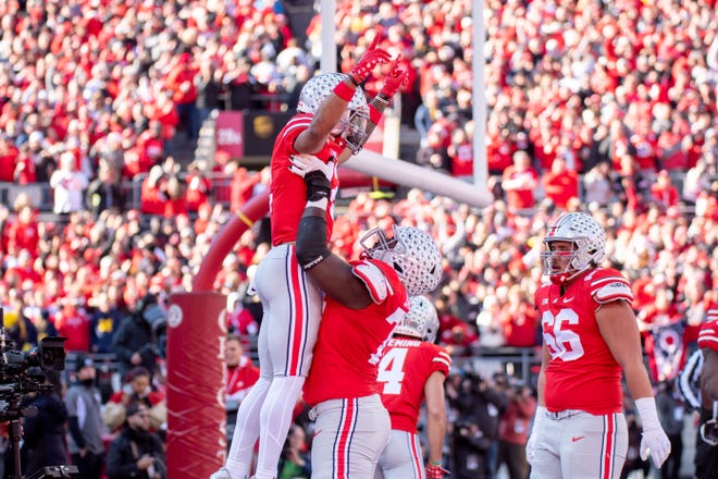 Ohio State offensive lineman Donovan Jackson lifts wide receiver Emeka Egbuka after Egbuka scored a touchdown during the first quarter.