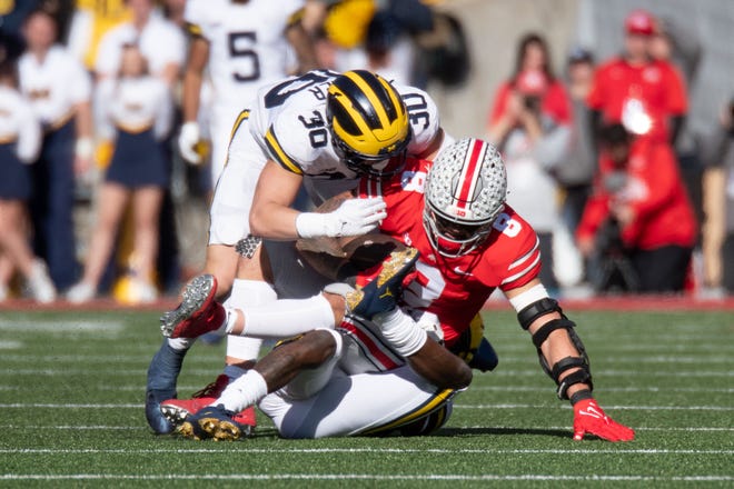 Ohio State tight end Cade Stover is tackled by Michigan wide receiver Will Rolapp, top and Michigan defensive back Rod Moore during the second quarter.