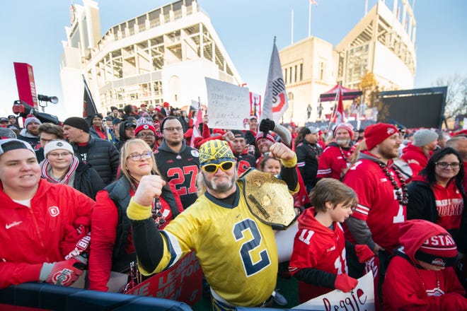 Michigan fan Hank Hogan, of Angola, Indiana, is outnumbered by Ohio State fans while watching the Fox Big Noon Kickoff before the game.