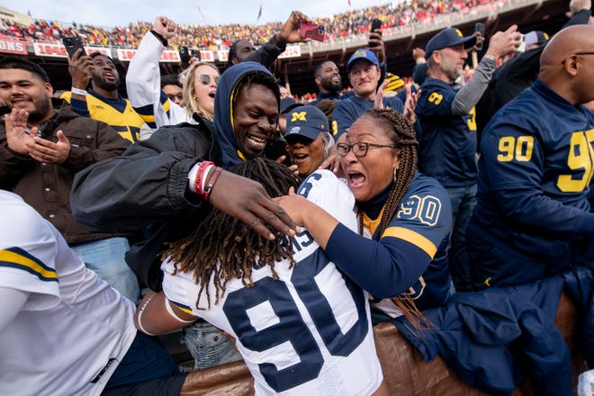 Michigan linebacker Mike Morris is hugged by the fans after the 45-23 win over Ohio State.