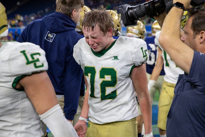 Lumen Christi's Drew Sweeney (72) is overcome with tears of joy during the handshake line after winning the Division 7 state title game.
