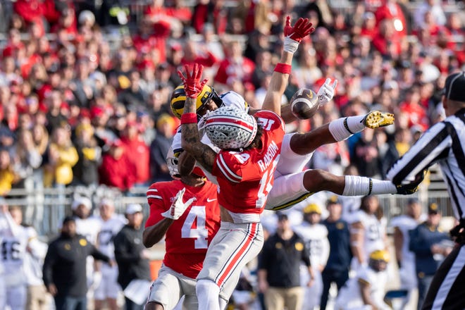 Ohio State safety Lathan Ransom, right, received a pass interference penalty on this play with Michigan wide receiver Cornelius Johnson and Ohio State cornerback JK Johnson during the fourth quarter.