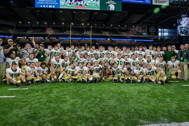 Jackson Lumen Christi poses with the Division 7 state championship trophy after defeating Traverse City St. Francis at Ford Field.