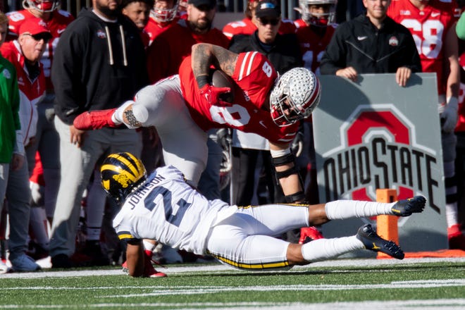 Ohio State tight end Cade Stover is tackled by Michigan defensive back Will Johnson during the second quarter.