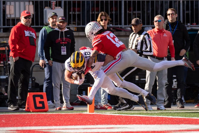 Michigan tight end Colston Loveland dives into the end zone for a touchdown while being defended by Ohio State safety Lathan Ransom during the third quarter.