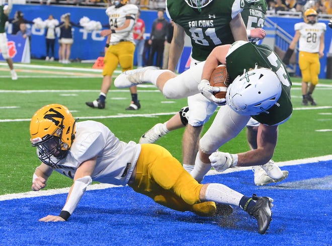 West Catholic's Joe Debski goes over Negaunee's Gavin Jacobson for a touchdown in the second half.