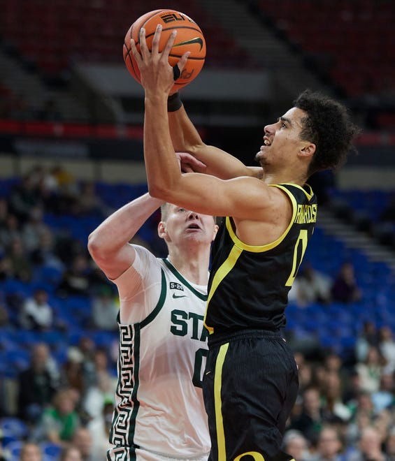 Oregon guard Will Richardson, right, shoots over Michigan State forward Jaxon Kohler during the first half.