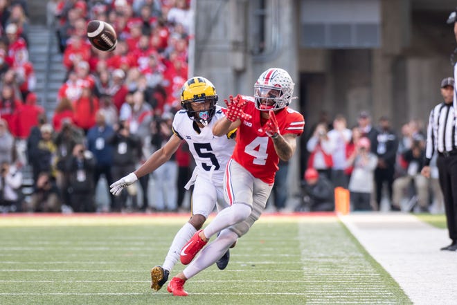 Ohio State wide receiver Julian Fleming hauls in a pass while being defended by Michigan defensive back DJ Turner during the fourth quarter.