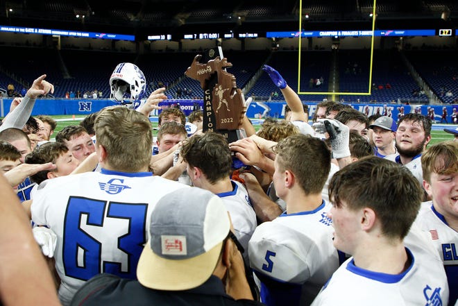 Gladwin players celebrate with their trophy after defeating Frankenmuth, 10-7, in the Division 5 state championship Saturday, Nov. 26, 2022, at Ford Field in Detroit.