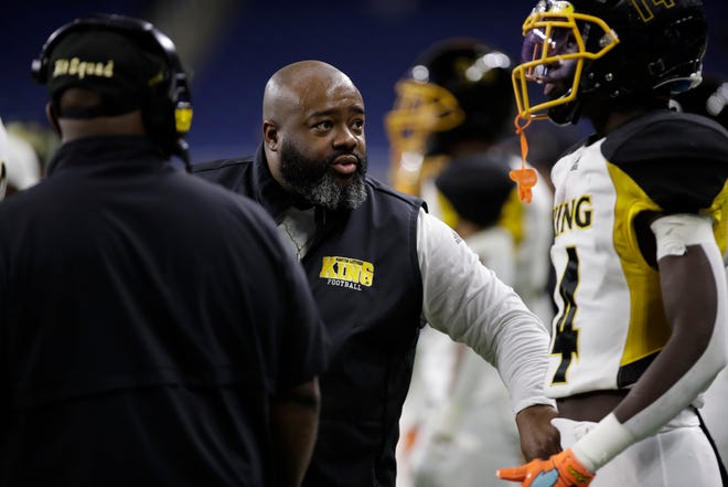 Detroit Martin Luther King head coach Tyrone Spencer talks with junior wide reciever DeWayne Dickerson (14) on the sidelines during the second half of the division 3 championship game against Muskegeon Saturday at Ford Field. Photo by: Brian Sevald / Special to the Detroit News