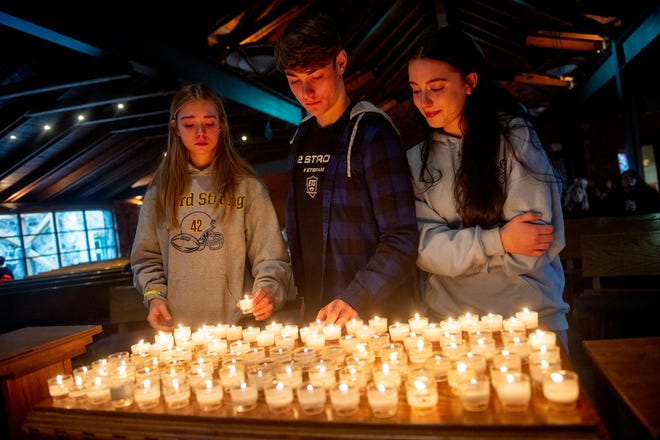 From left to right: Oxford High School freshman Camryn Quidort, 14, her brother senior Quiz Quidort, 17, and senior Veronica Heinemann, 17, light votive candles in remembrance of the four slain students, six injured students, one injured teacher as well as staff and first responders in an effort to heal the Oxford community through prayer and worship on Wednesday, Nov. 30, 2022 at St. Joseph Catholic Church in Lake Orion.