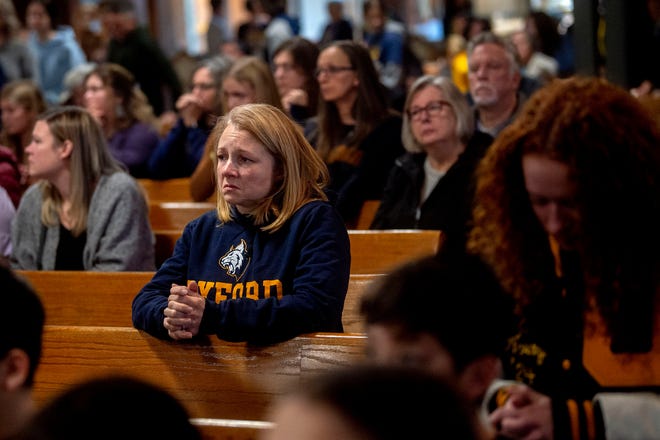 Oxford, Mich., resident Andrea Curtis kneels and prays during a Mass service to honor the Oxford school shooting victims, Wednesday, Nov. 30, 2022, at St. Joseph Catholic Church in Lake Orion, Mich.