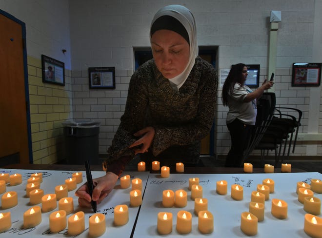 Inaya Soufan/Shehab writes words of support and comfort for those in Oxford during a Dearborn PTA Council vigil in remembrance for those impacted by last year's shooting at Oxford High School at Dearborn Public Schools Administrative Service Center in Dearborn, Michigan on November 30, 2022.